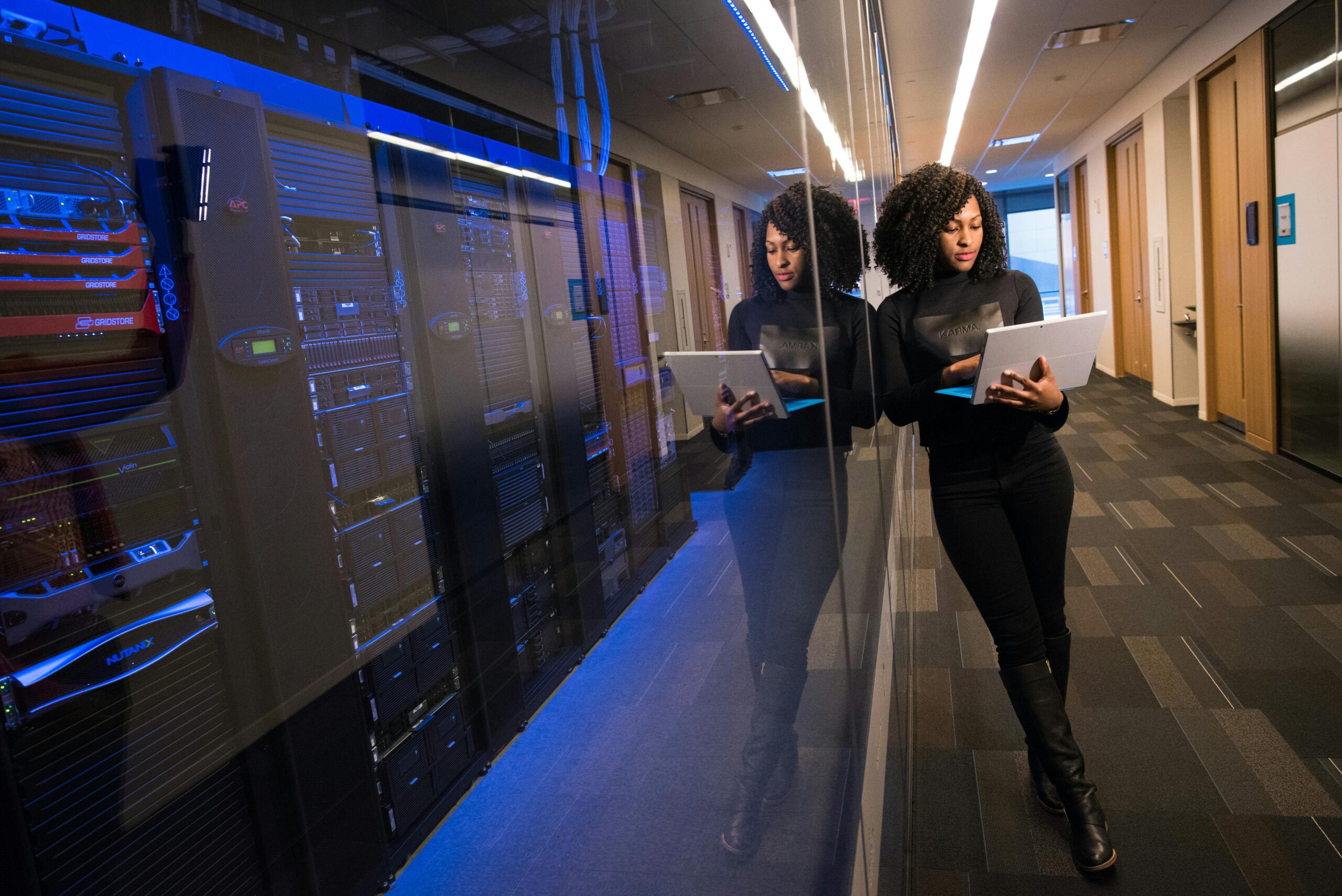 Jeune femme devant une vitre de datacenter